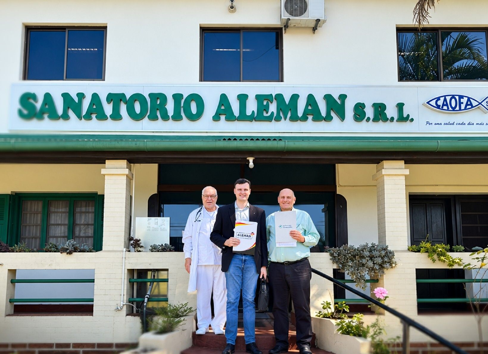 Firma del convenio con el Centro de Radioterapia Concordia frente a la entrada del Sanatorio Alemán